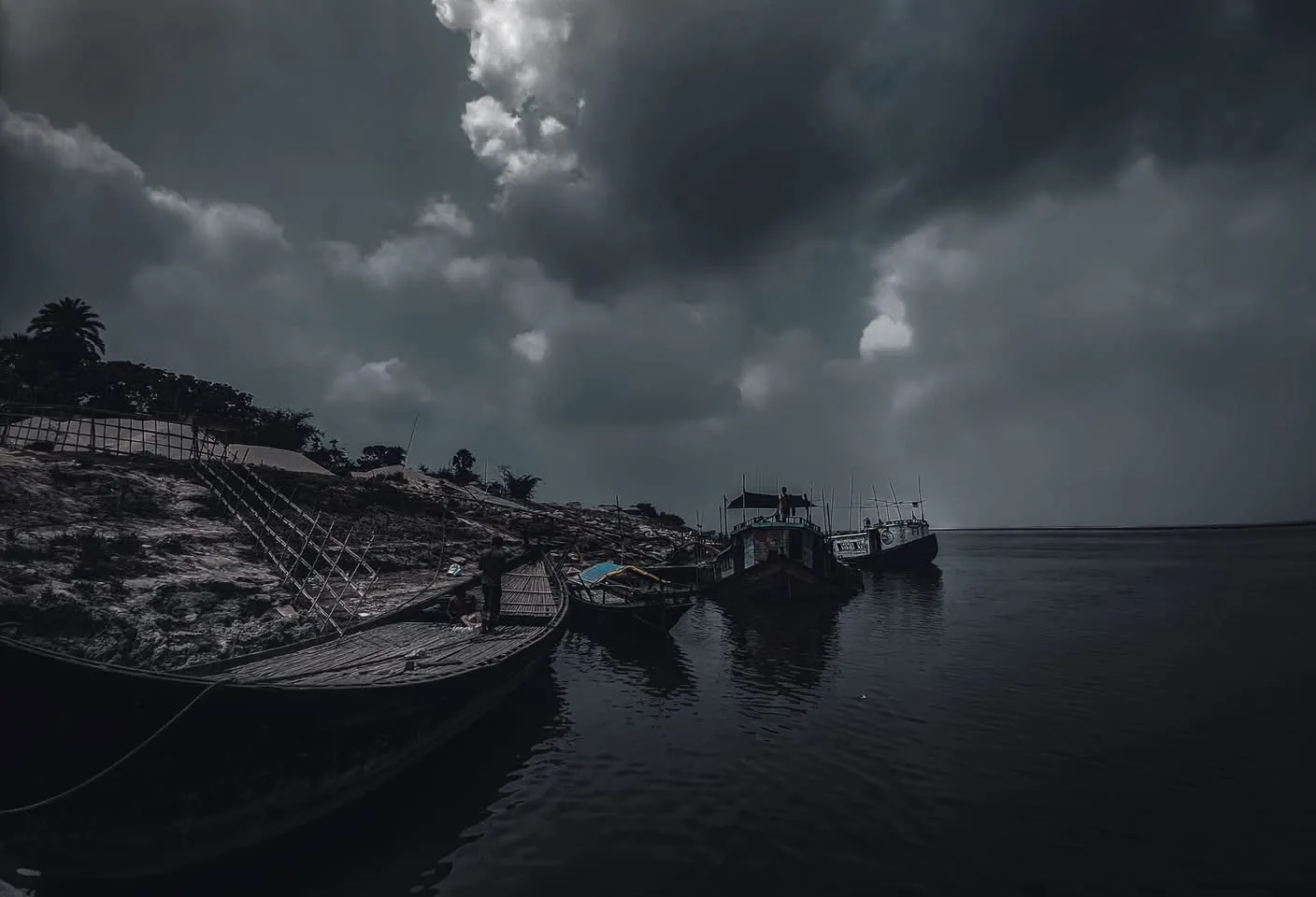 Before the rain: Heavy clouds over the river, the boats tied up and waiting.
