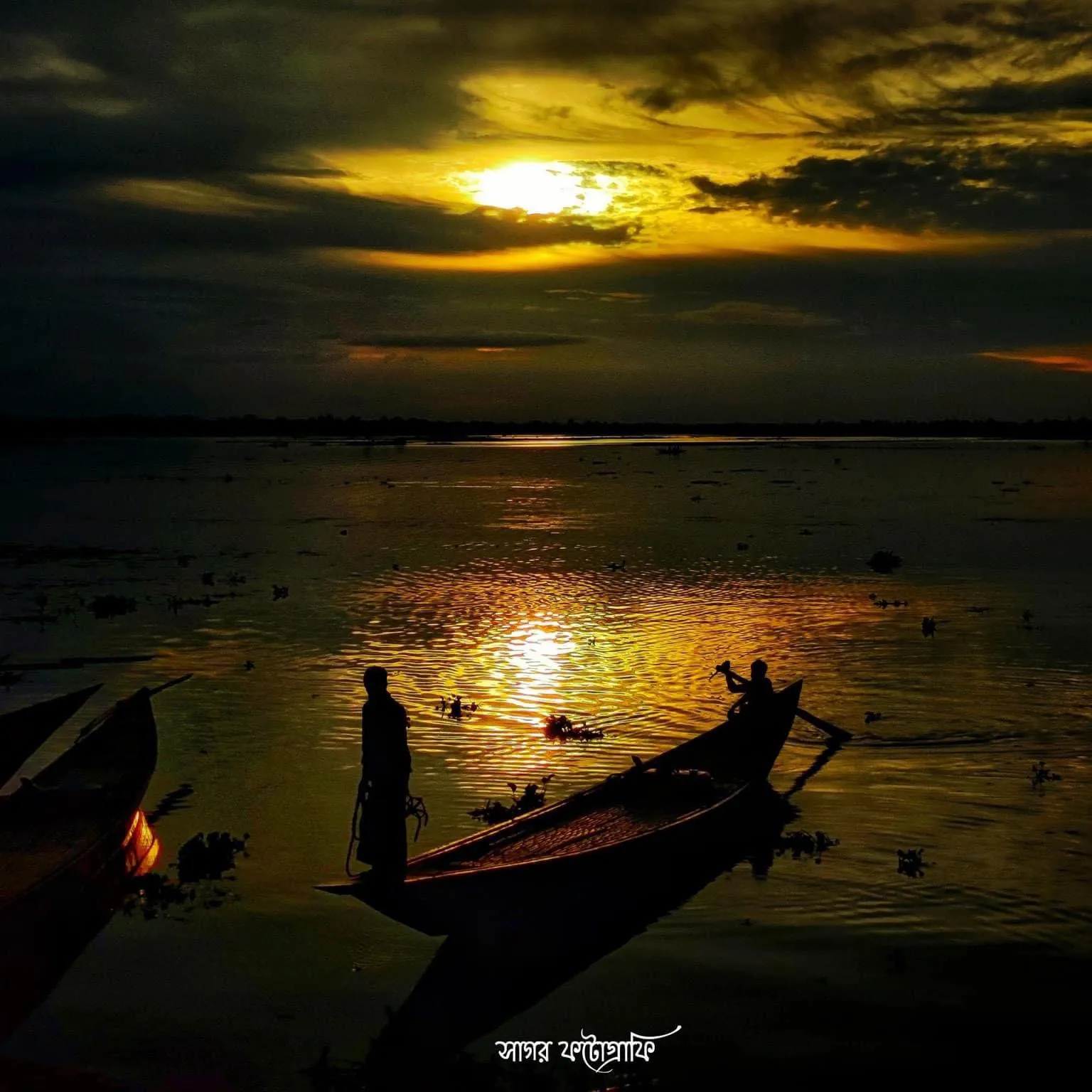 Last light: The sun sets behind a fisherman's boat and turns the river to gold.