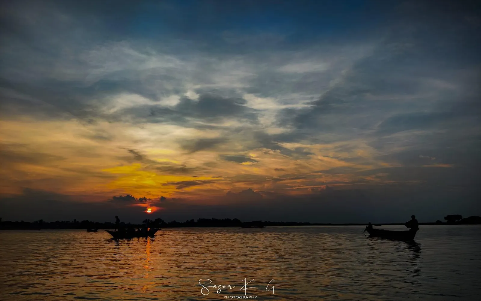 Horizon: A thin line of fire between the clouds and the river.
